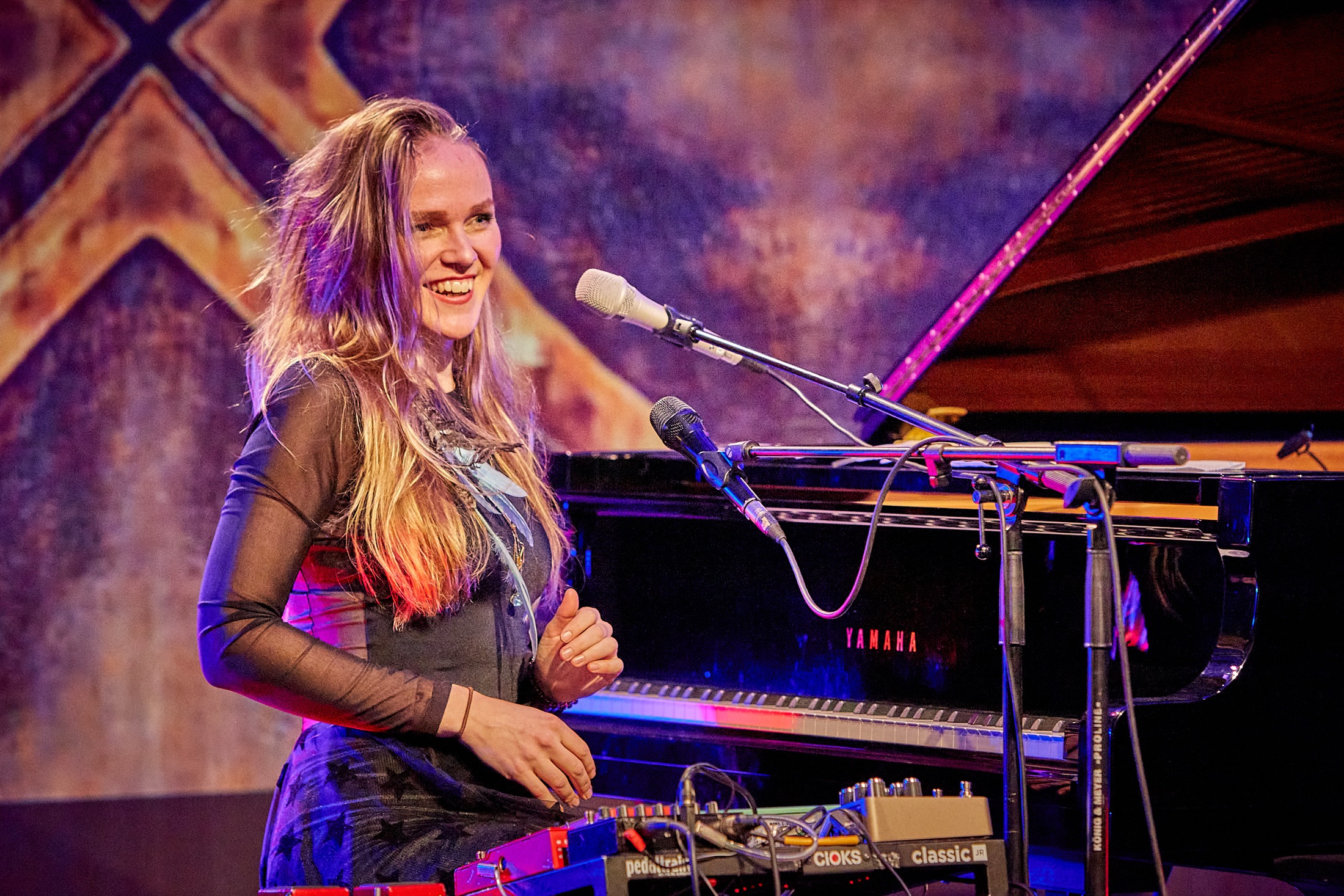 Kadri Voorand smiling at the piano during a live performance.